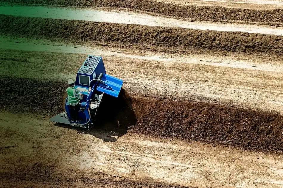 A windrow turner working the composting rows