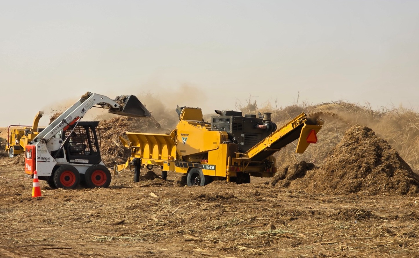 Landscape material being processed by a loader and shredding equipment